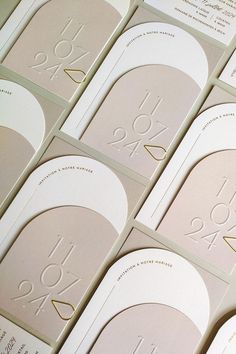 many different business cards with numbers and symbols on them, all in white and gold