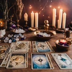 tarot cards and candles sit on a table in front of an arrangement of lit candles