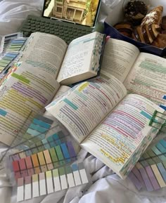 an open book sitting on top of a bed next to a laptop and other items