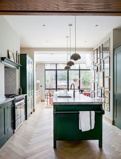 a kitchen with green cabinets and an island