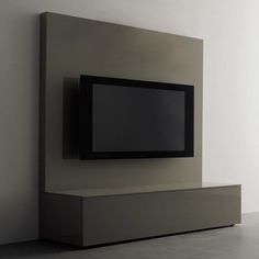 an entertainment center with a flat screen tv mounted on it's side, in front of a white wall