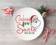 a plate with cookies for santa on it next to candy canes