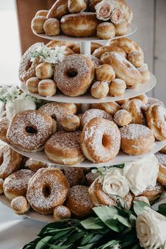 three tiered trays filled with donuts and flowers