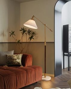 a living room filled with furniture and a lamp on top of a wooden floor next to a doorway