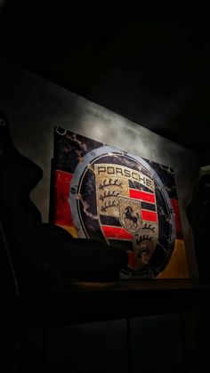 the porsche logo is shown on display in this dark room