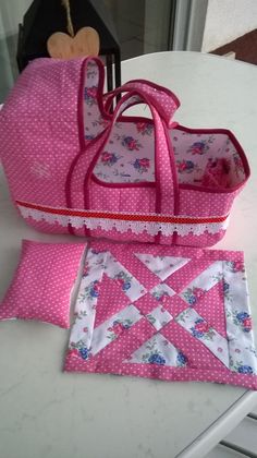 a pink purse sitting on top of a table next to a piece of cloth and a pair of scissors