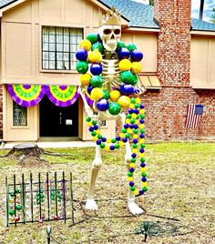 a skeleton is standing in front of a house decorated with balls and decorations for halloween