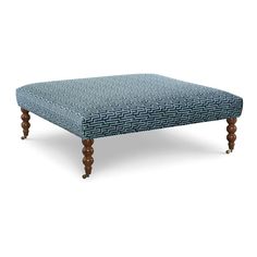 the footstool is made from wood and has a blue patterned fabric on it