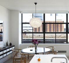 a dining room table and chairs in front of a large window