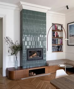 a living room with a fireplace and bookshelf