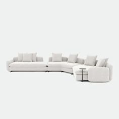 a white sectional couch with pillows on it