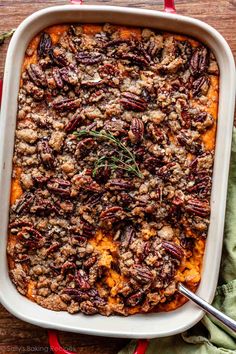 a casserole dish filled with sweet potatoes and pecans