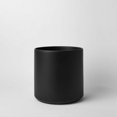 a black cup sitting on top of a white table