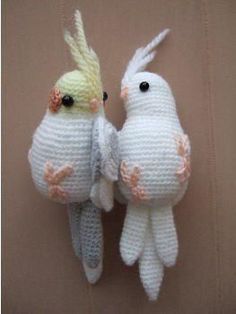 two white crocheted birds hanging on a wall