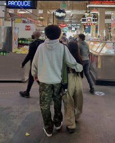 two people walking down the street in front of a food court