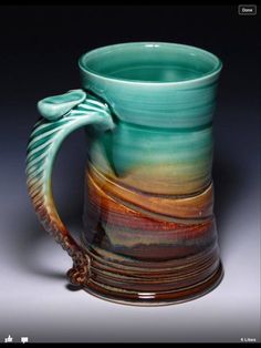 a coffee mug with a handle on the side and an ocean wave painted on it