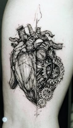 a black and white heart tattoo on the back of a woman's thigh, with gears