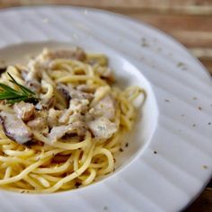 a white plate topped with pasta covered in sauce