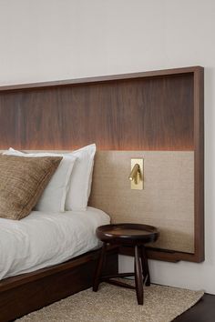 the headboard is made up with wood and white linens, along with pillows