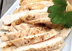 sliced chicken and potatoes on a white platter with parsley garnishes