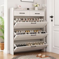 a white shoe rack filled with pairs of shoes next to a door and potted plant