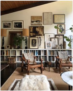 a living room filled with lots of furniture and pictures on the wall above it's bookshelf