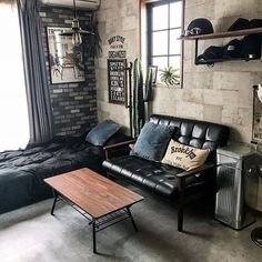 a living room filled with furniture next to a window and a wall covered in posters