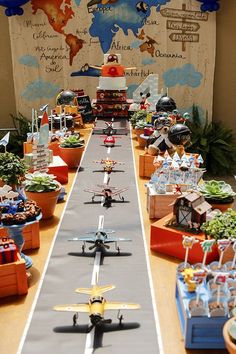 a long table filled with lots of toy airplanes and toys on top of each other