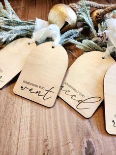 four wooden tags that say something you want to do with the holiday decorations in the background