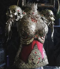 the back of a woman's body with skulls on it and other items around her