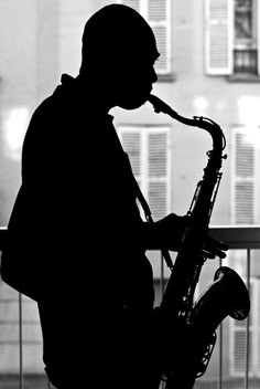 black and white photograph of man playing saxophone