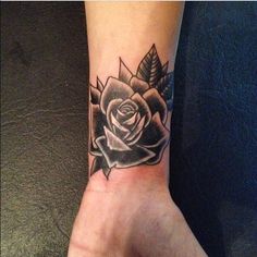 a black and white rose tattoo on the wrist