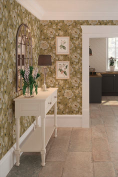 the hallway is decorated with wallpaper and pictures on the walls, along with a white console table