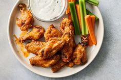 chicken wings, carrots and celery sticks on a plate with ranch dressing