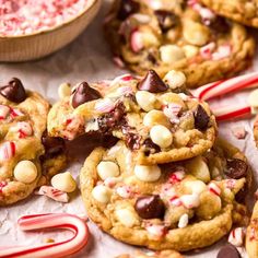 chocolate chip cookies with candy canes and marshmallows are on the table