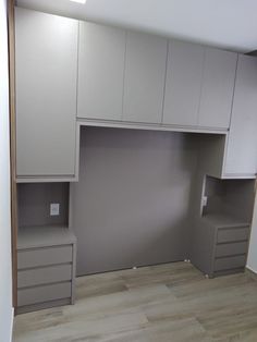 an empty room with white cabinets and drawers