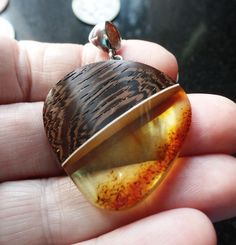 Striking Baltic Amber and Wood Silver Fitted Pendant. A very Modern Design, and a Stylish Statement Piece. Polished smooth on the front and sides, rough bottom right hand edge, adds to its charm. Amber is the Birthstone for Taurus and is considered a Lucky Stone Measures 3.50cm wide by 4.88cm the top of the bale. Weighs 6.9g. Shipping will be combined to reduce postage costs and includes a Gift Box made in England using 100% FSC Accredited and 100% Recyclable Board and Paper. Item will be dispat Taurus Birthstone, Lucky Stone, Baltic Amber, Right Hand, Statement Pieces, Pendant Necklaces, Phone Number, Cognac, Amber