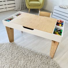 a wooden table with drawers underneath it in a living room next to a green chair