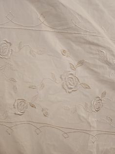 an embroidered sheet with roses on it