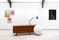 an office desk with a large white ball next to it and pictures on the wall