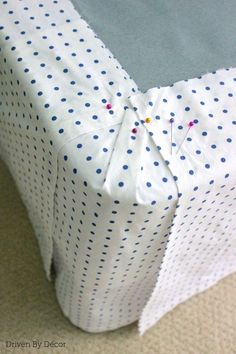 a white and blue polka dot covered bed with buttons on the pillow cover that has been sewn