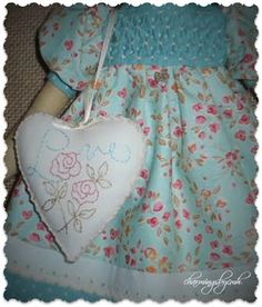 a doll with a heart shaped pillow hanging from it's back