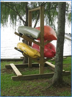 canoes are lined up on a stand near the water