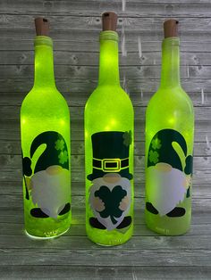 three st patrick's day green beer bottles with shamrock hats and clovers on them