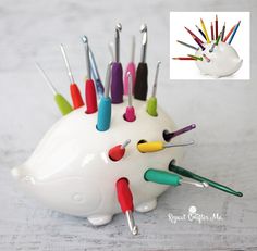 a white hedgehog shaped pen holder with colorful needles sticking out of it