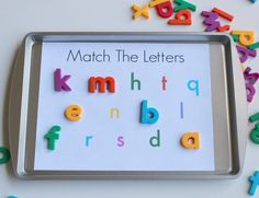 a metal tray with magnets on it and letters scattered around the letter's