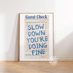 a poster with the words slow down you're doing fine on it in front of a white wall