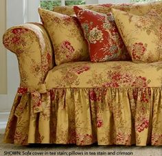 a couch with red and gold pillows on it