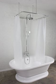 a white bath tub sitting in a bathroom next to a shower head and hand rail