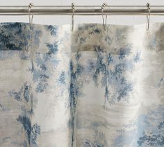 a blue and white curtain hanging on a metal rod